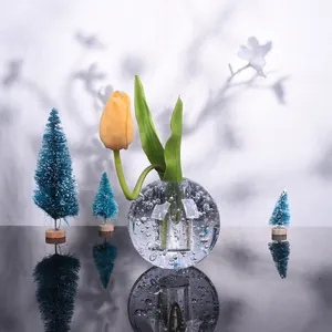 Künstlerisches Detail einer runden Glasblasenvase mit einer schönen gelben Tulpe