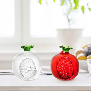 Vista detallada de figuras de granada de cristal rojo y transparente en un escritorio brillante