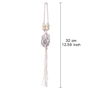 Détail d'une suspension en macramé faite main avec pierre brute et pompons, longueur de 32 cm