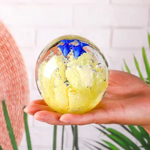 Vista dettagliata di una sfera di cristallo con corallo giallo e pesci blu all'interno