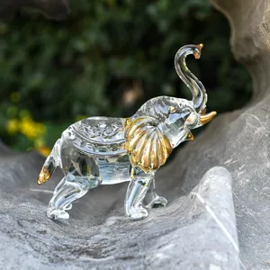 Close-up view of transparent glass elephant figurine with gold accents on ears and tusks