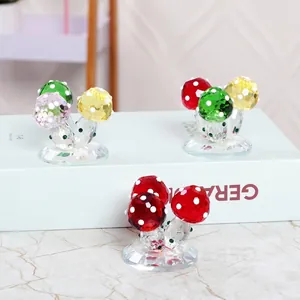 Figurines de champignons en cristal facetté de différentes couleurs sur des livres blancs