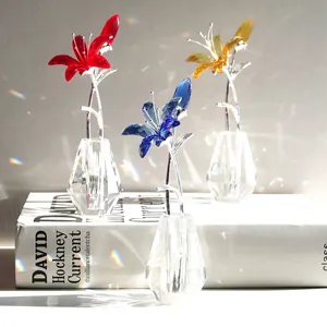 Set mit roten blauen und gelben Kristalllilien in Glasvasen auf einem weißen Buch