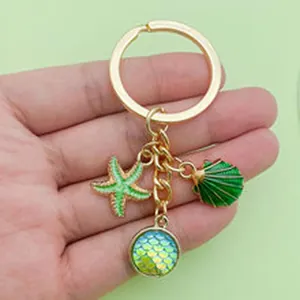 Detailed view of ocean-themed keychain featuring starfish and green shell charms