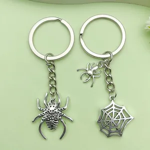 Close-up of Halloween silver alloy spider and spiderweb keychains with skeleton pattern details
