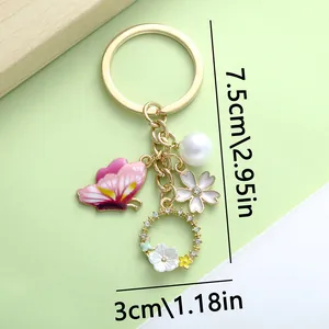 Detailed view of pink butterfly and pearl charm keychain with 7.5cm length markings