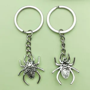Macro view of silver spider keychain showing detailed texture on front and back sides.