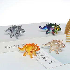 Detail showing four handcrafted crystal triceratops dinosaur figurines in various colors
