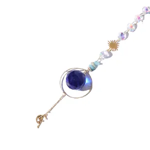 Kristallen zonnevanger hanger met blauwe geslepen bal en gouden fee-bedel