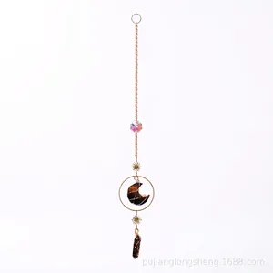 Detailed view of the moon-shaped tiger eye stone and gold star on the hanging ornament
