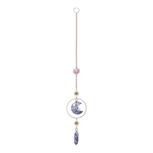 Detailed macro view of moon-shaped crystal and raw stone pillar suncatcher with gold stars