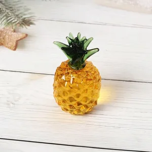 Detaillierte Ansicht einer handgefertigten Kristallglas-Ananasfigur auf weißem Holztisch