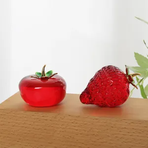 Detailaufnahme von dekorativen roten Kristall-Erdbeeren und Tomaten auf Holzsockel.