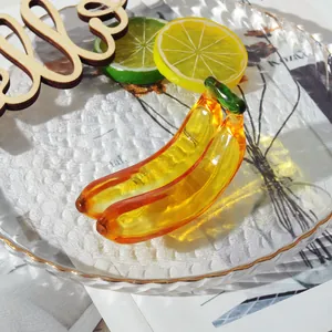 Detailaufnahme einer handgefertigten Dekofigur: gelbe Glasbanane mit Stielen