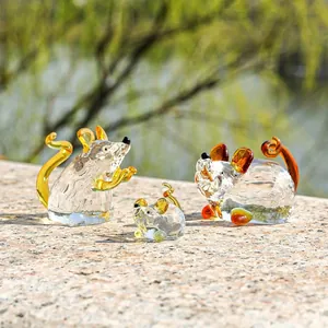 Vista dettagliata di tre figurine di topi in cristallo fatte a mano con dettagli ambrati