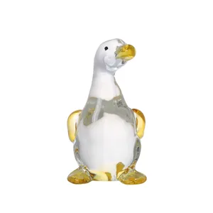 Detailed view of a hand-blown glass duck figurine with clear, white, and yellow accents