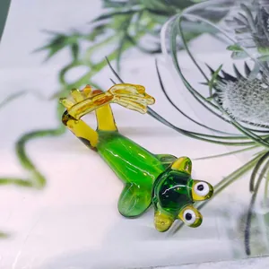 Detailed macro view of a cute green glass frog figurine in a relaxed lying pose