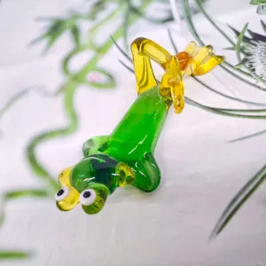 Detailed close-up of a green and yellow crystal glass frog figurine in a yoga pose