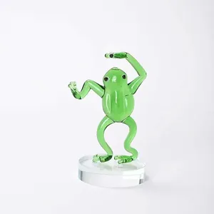Close-up detail of a handcrafted green glass kung fu frog figurine on clear base