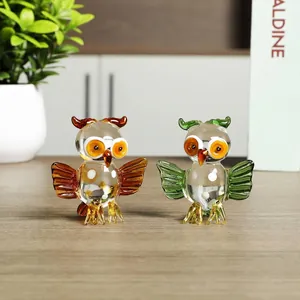 Detail view of two colorful handcrafted glass owl figurines displayed on a wooden office desk