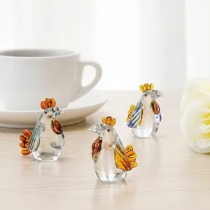 Inquadratura dettagliata di tre figurine di gallo in cristallo con accenti ambrati