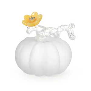 Detailaufnahme eines mattweißen Glaskürbis-Ornaments mit einer dekorativen gelben Blume