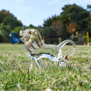 Detailed view of handcrafted glass lion figurine with gold accents on green grass