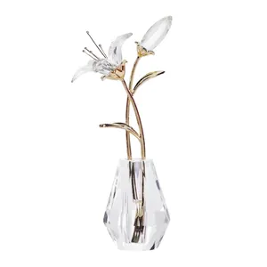 Detaillierte Nahaufnahme einer Kristalllilie mit goldenen Stielen in einer klaren Vase.