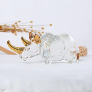 Detail view of a clear glass rhinoceros figurine with golden gilded horns and ears decor