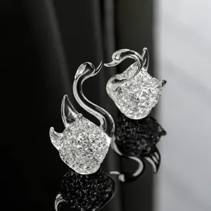 Paar elegante Kristallschwan-Ornamente mit Glaskrusten-Textur auf schwarzer Reflexionsfläche