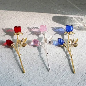 Elegante kristallen rozen voor op het bureau met gouden stelen in rood, roze en blauw