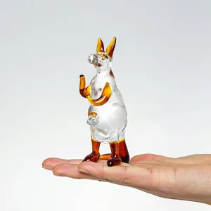Mini statuina di canguro in cristallo con accenti ambrati tenuta in una mano