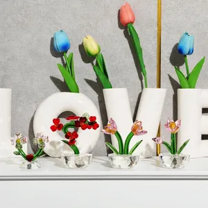 Detailed view of assorted crystal glass flower figurines on a decorative white shelf