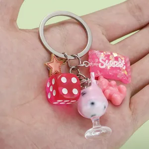 Detail view of a creative resin keychain featuring pink bear, dice and sweet candy charms
