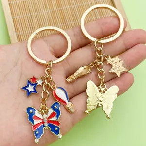 Detail view of USA flag themed butterfly and hot air balloon charms on a gold keychain