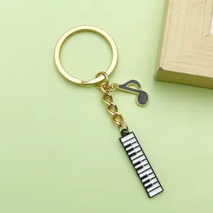 Detailed view of musical note and piano key charms on golden alloy keychain