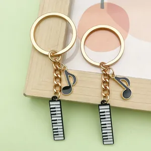 Close-up of golden music-themed keychains with piano keys and musical note charms