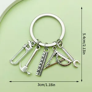 Tool-themed metal keychain with saw and hammer charms, measuring 5.4cm by 3cm, silver finish