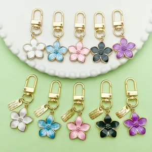 Detailed macro view of pearlized enamel flower keychains available in five vibrant colors
