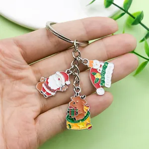 Cute Christmas keychain with Santa Claus, reindeer, and snowman charms in hand.