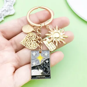 Detailed view of a gold alloy keychain featuring sun, heart, and tarot card charms