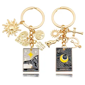 Detailed view of gold-tone tarot card keychains featuring The Star and The Moon charms.
