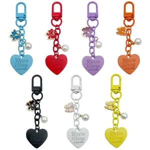Detailed macro view of colorful heart keychains with butterfly and pearl decorative charms