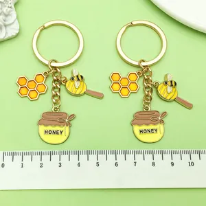 Vue détaillée de mignons porte-clés émaillés abeille avec règle pour référence de taille
