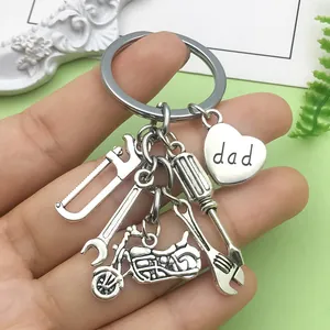 Silver keychain featuring detailed screwdriver, wrench, saw, and heart charm with 'dad'.