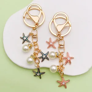 Macro detail of handmade colorful starfish and pearl gold-tone keychains for bags
