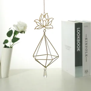 Close-up of golden lotus sun catcher with geometric frame and crystal prism