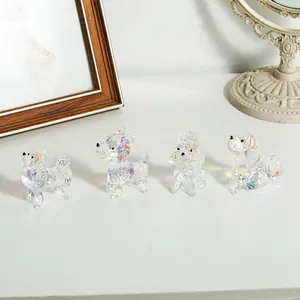 Nahaufnahme von vier bunten Mini-Kristallglas-Hundefiguren auf einer weißen Fläche