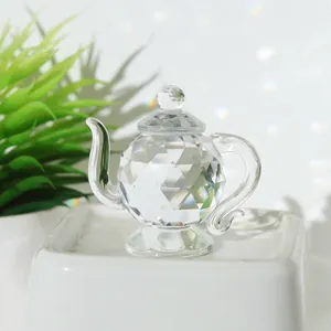 Detailed close-up of a faceted transparent crystal teapot miniature ornament for decor.