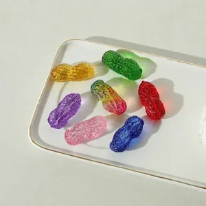 Detailansicht farbenfroher Erdnuss-Ornamente aus Kristallglas auf einem weißen Tablett